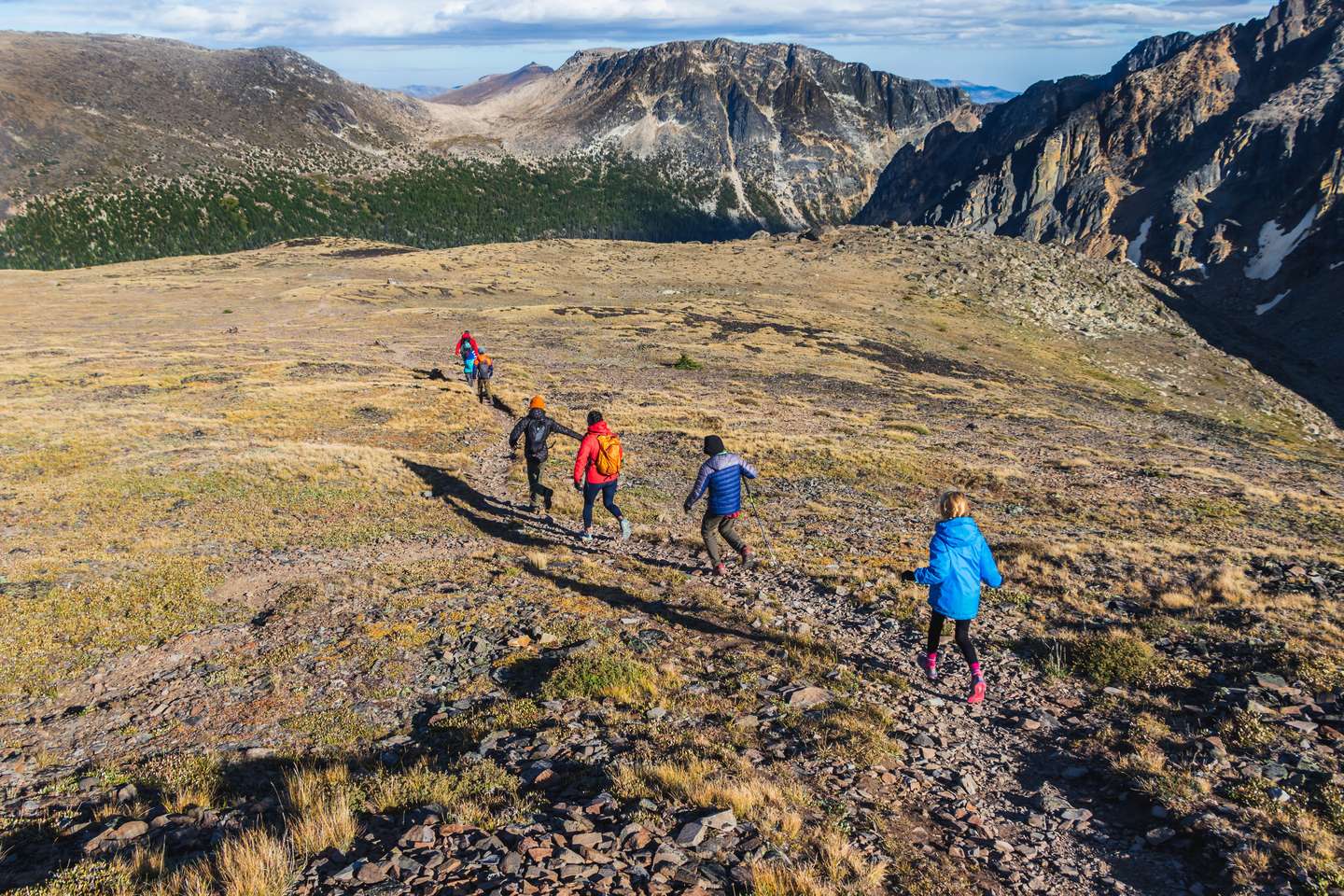 Children and adults hiking on a trail in the mountains