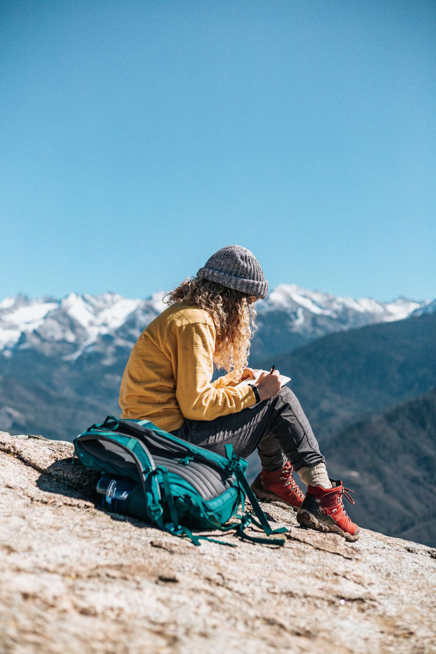 Girl journalling on a rocky surface